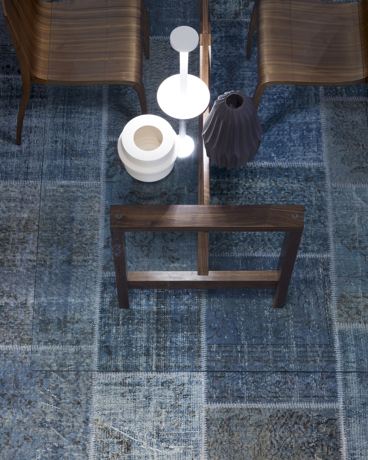 A gray-blue rug that complements the surfaces in a contemporary architectural space
