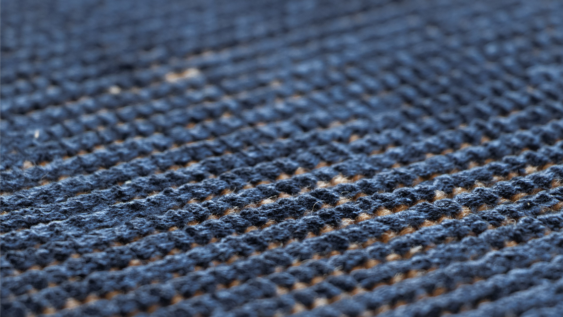 Woven structure of a blue handwoven rug, showing how it interacts with light and the density of the fabric