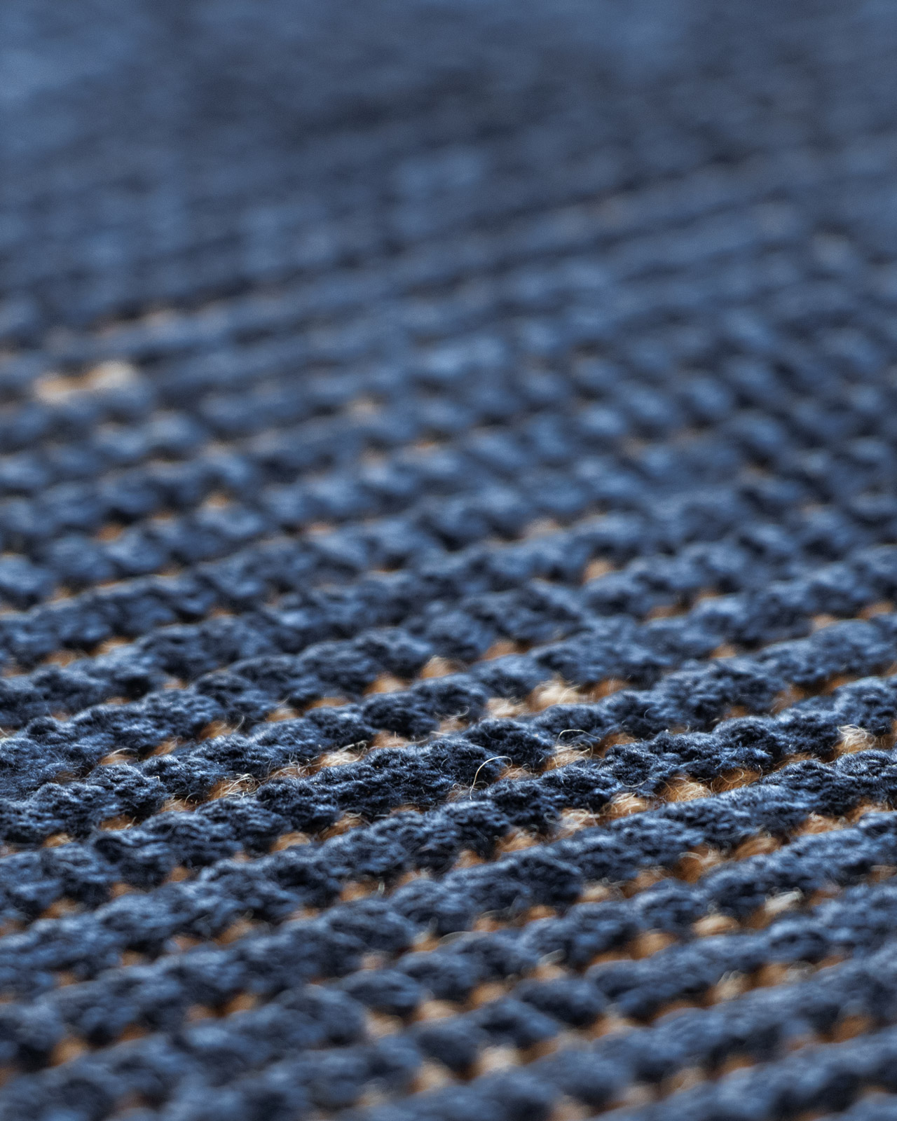 Woven structure of a blue handwoven rug, showing how it interacts with light and the density of the fabric