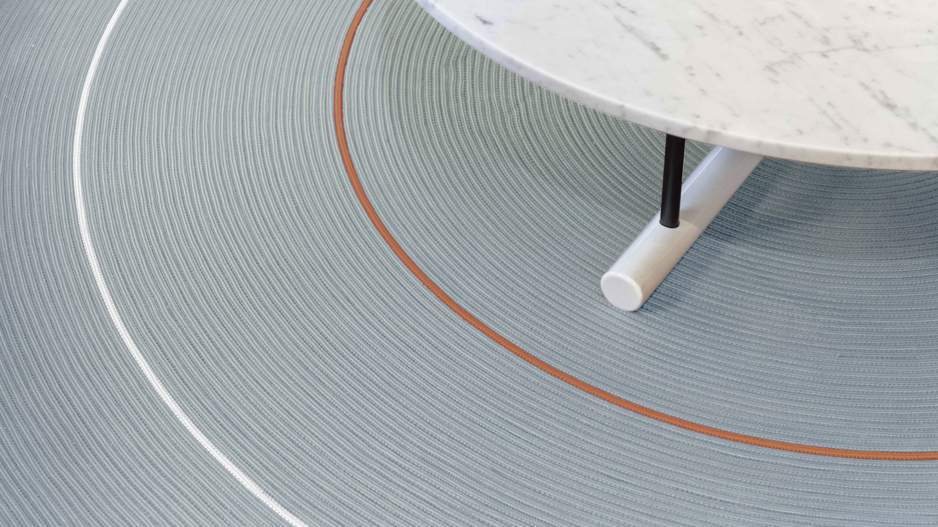 Close-up detail of a woven blue-gray rug texture with two-tone border