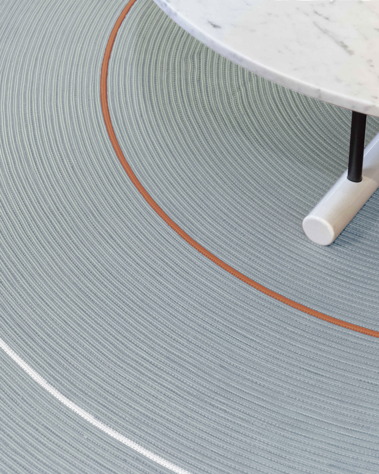 Close-up detail of a woven blue-gray rug texture with two-tone border